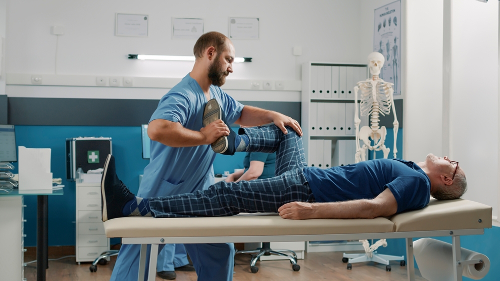 A man receiving a medical exam from a doctor at a whiplash treatment center.