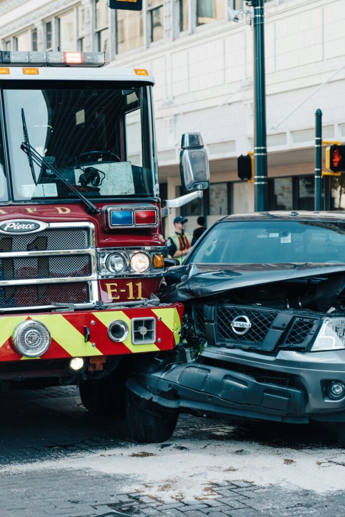 Emergency response to car accident victims with fire truck and damaged vehicle.