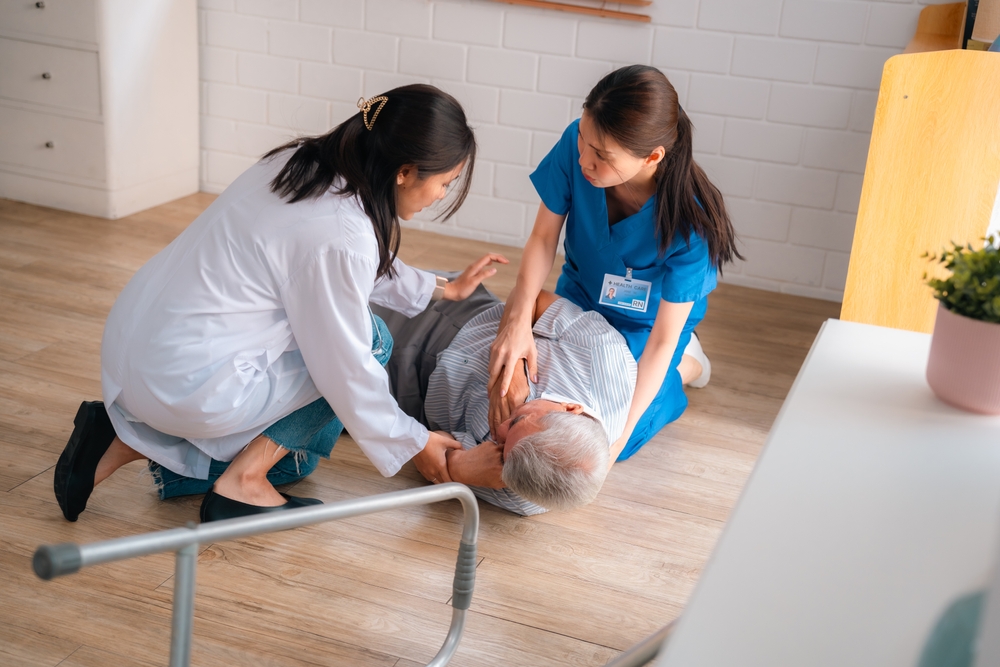 A woman aids a man on the floor, representing the care provided by Miami slip and fall medical specialists.