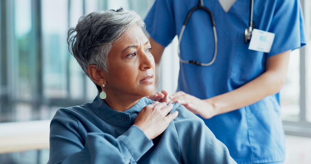 In a slip and fall clinic, a woman is seated with a nurse, who is providing support and guidance for her recovery.